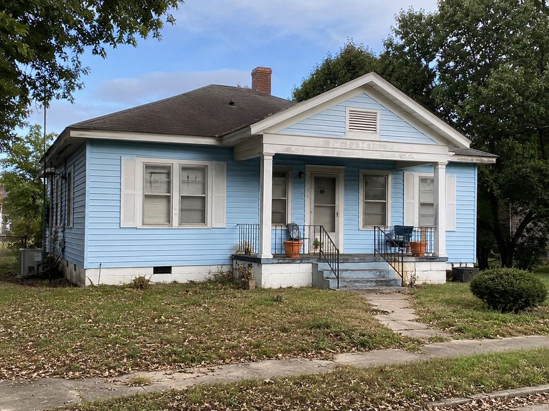 A blue cottage with a covered front porch