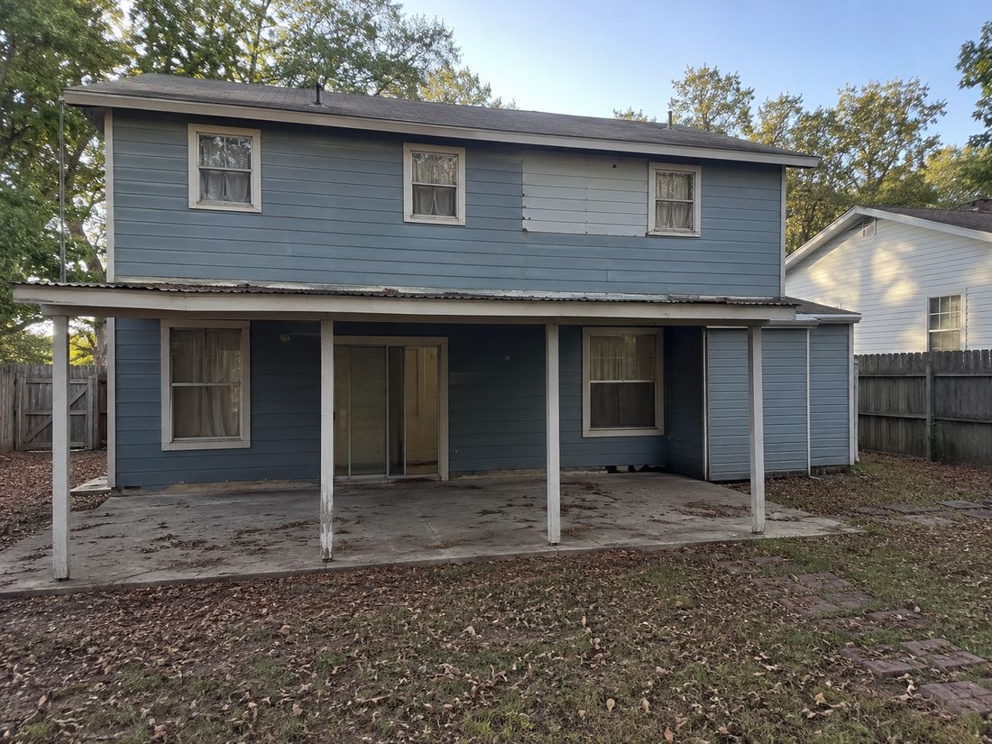 A blue two-story home with a carport
