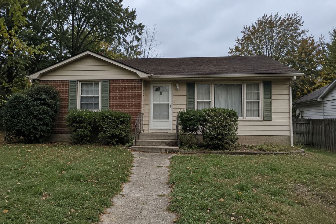 A modest brick ranch home with a center entry