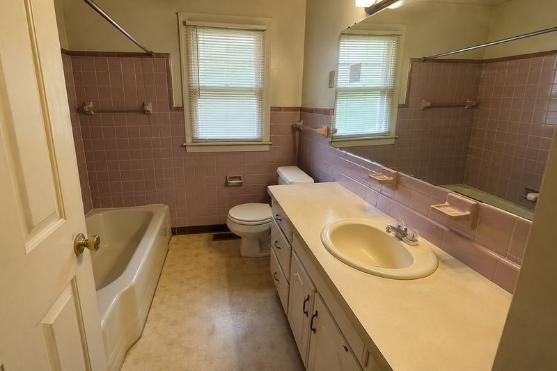 A dated pink-tile bathroom, the kind we buy every month